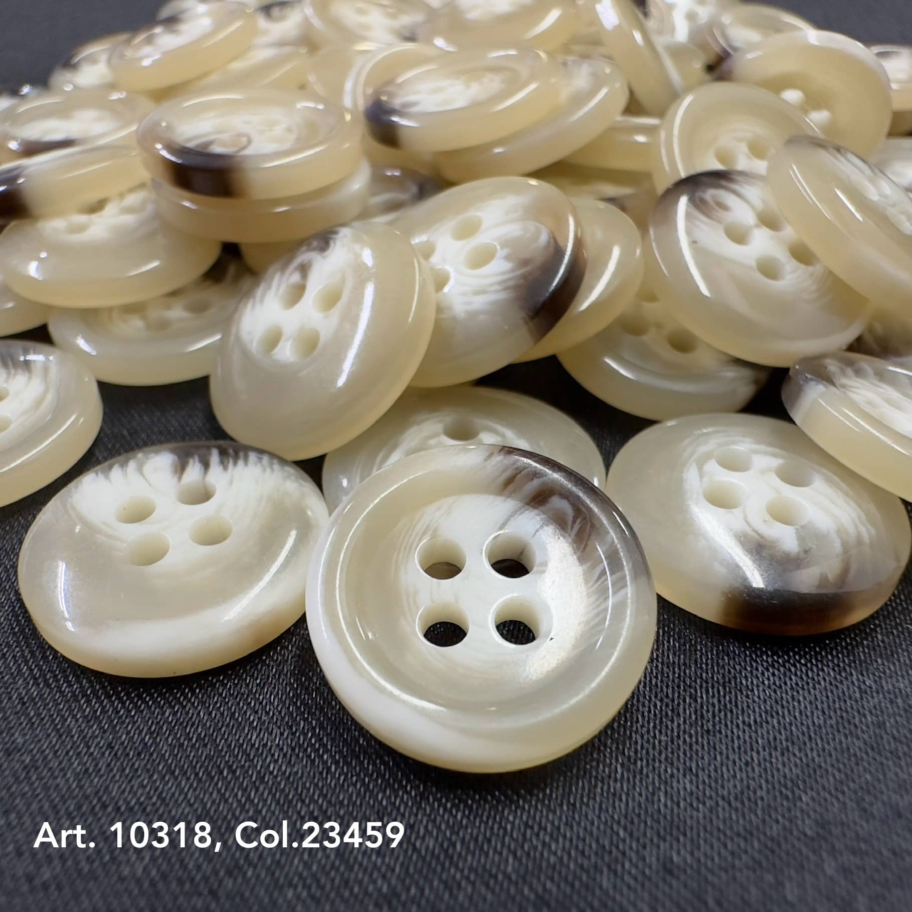 Cream and brown round suit and coat buttons with four holes from Buttonology Inc on dark fabric