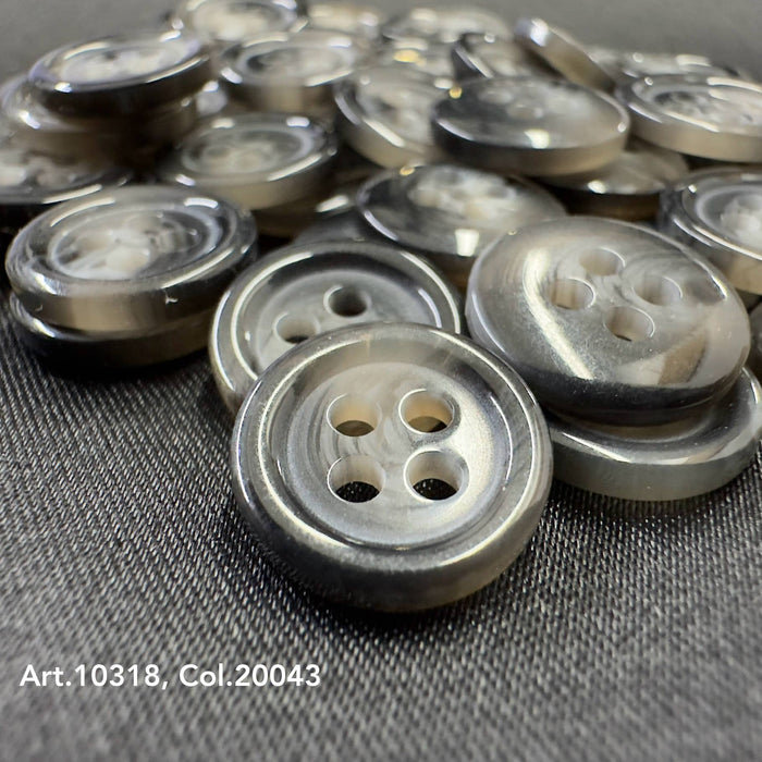 Close-up of silver suit and coat buttons with four holes by Buttonology Inc on black fabric