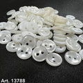 White 2 hole buttons by Buttonology Inc stacked on black fabric surface