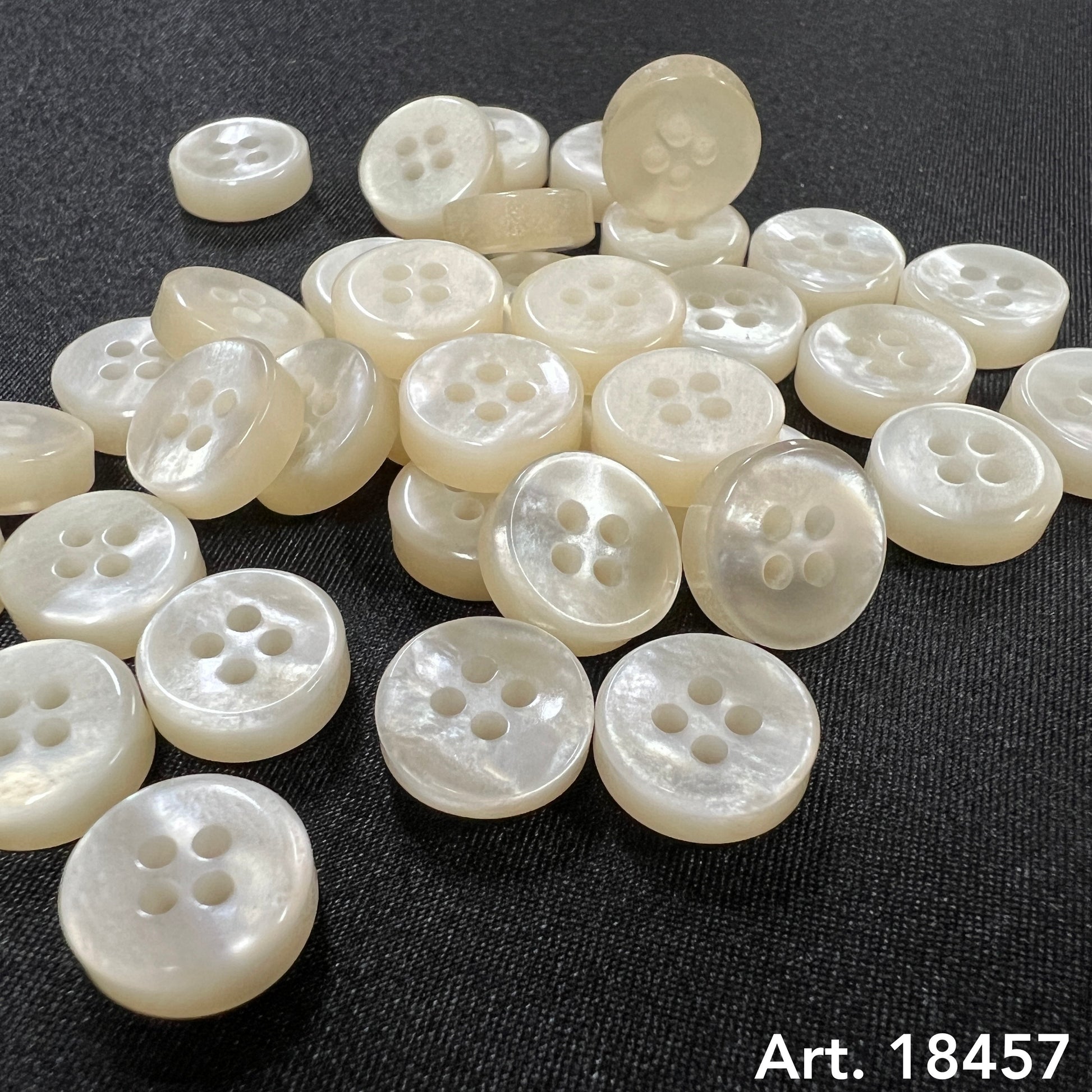 Collection of white 4 hole sewing buttons with a smooth, glossy finish for craft projects