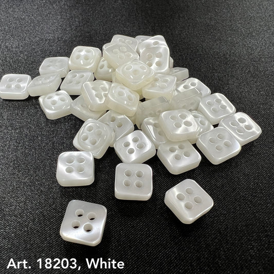 White square buttons bulk from Buttonology Inc with four holes on black fabric background