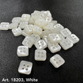 White square sewing buttons with four holes by Buttonology Inc. arranged on black fabric