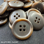 Wholesale four-hole buttons in brown shades by Buttonology Inc with a smooth finish stacked on fabric