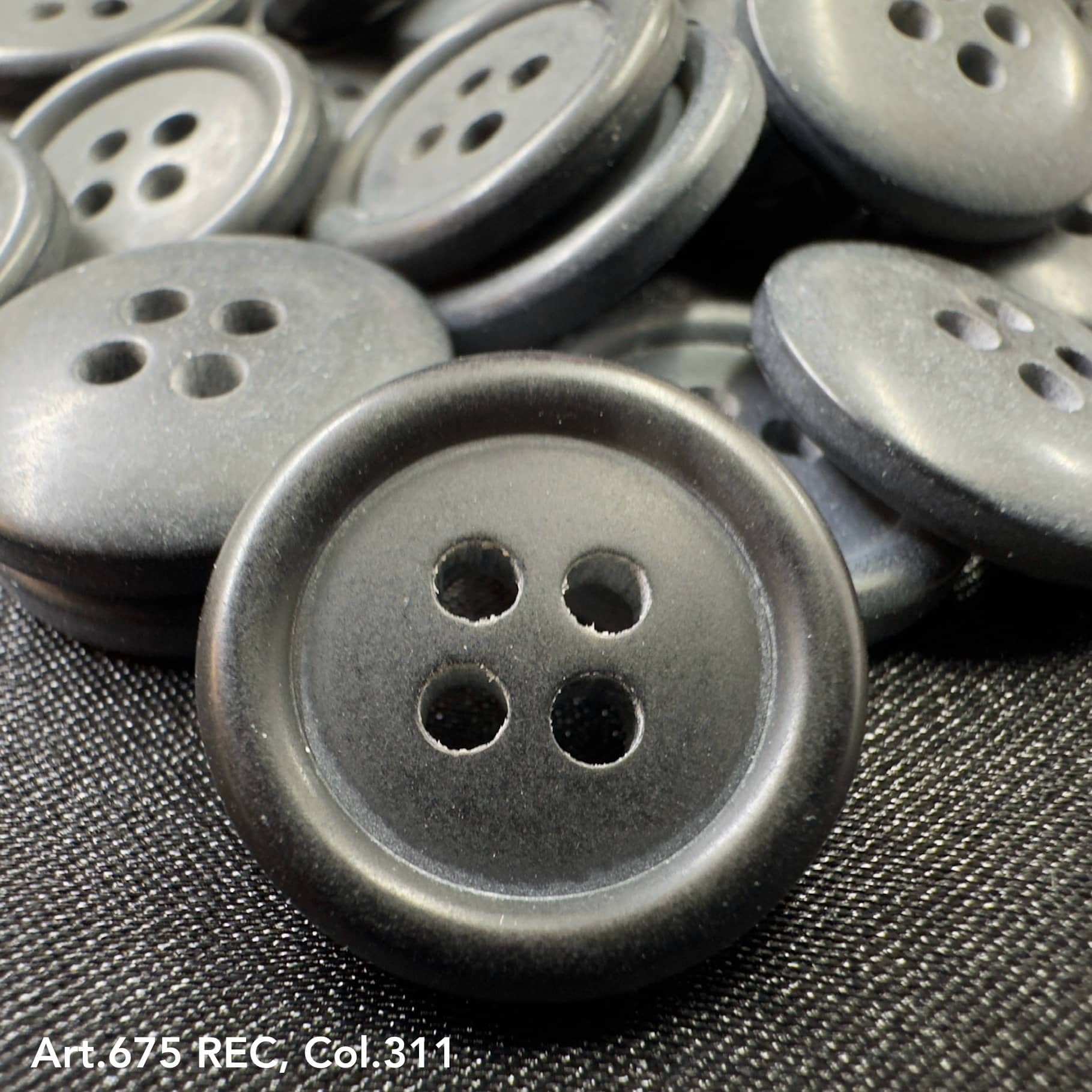 Wholesale four-hole buttons by Buttonology Inc in black with a matte finish close-up image